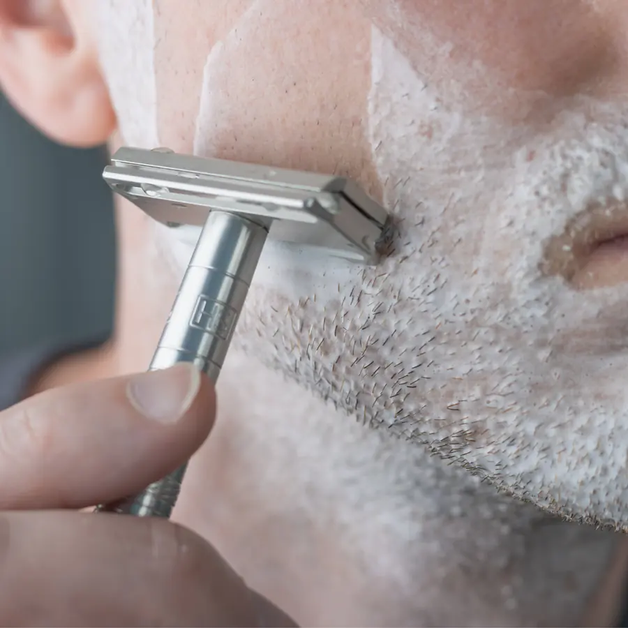 Man shaving with a Henson safety razor